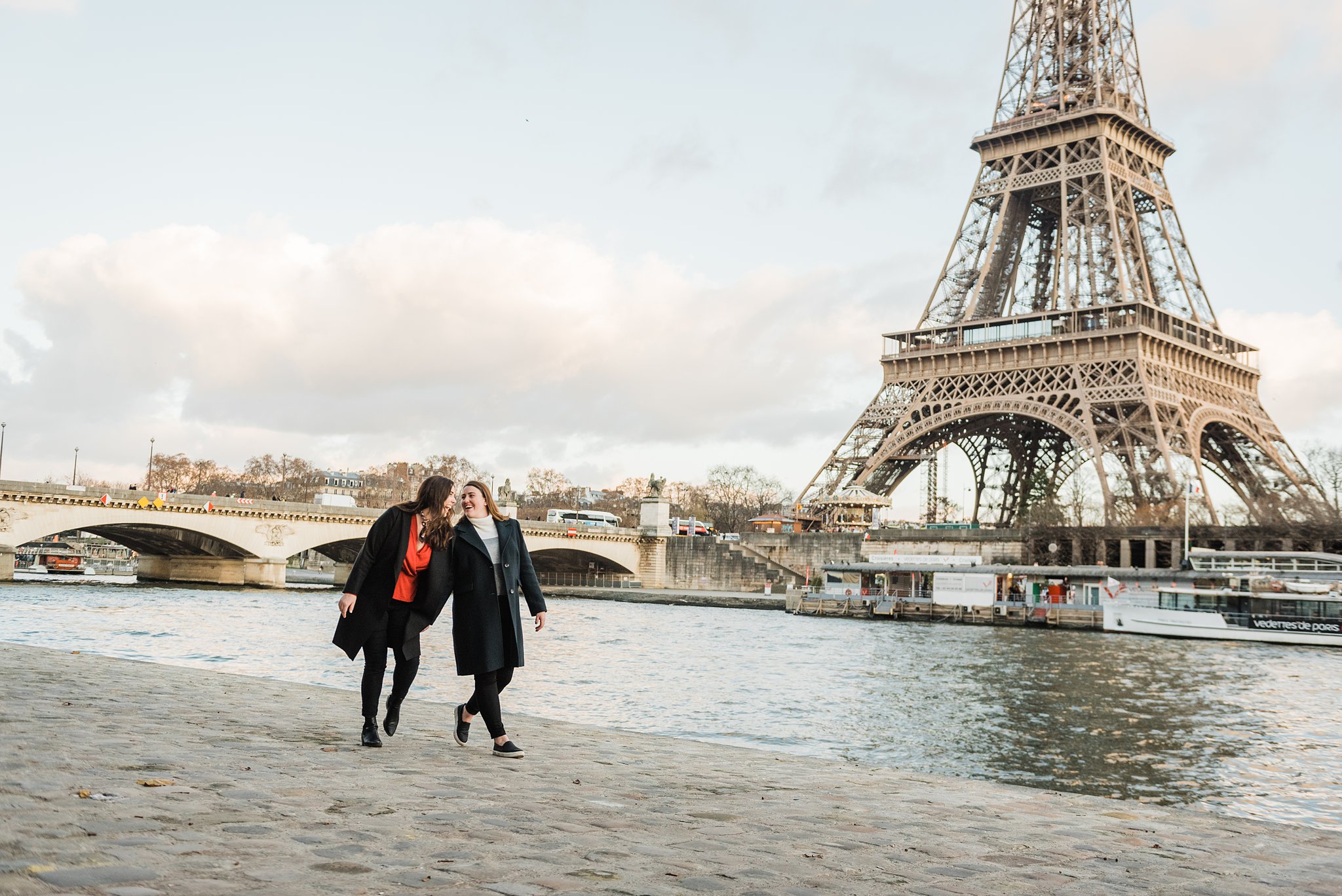Sisters on a Paris Photoshoot walking and laughing by the Seine River
